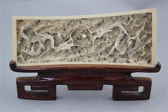 A Chinese ivory dragon plaque, early 20th century, 25cm., wood stand